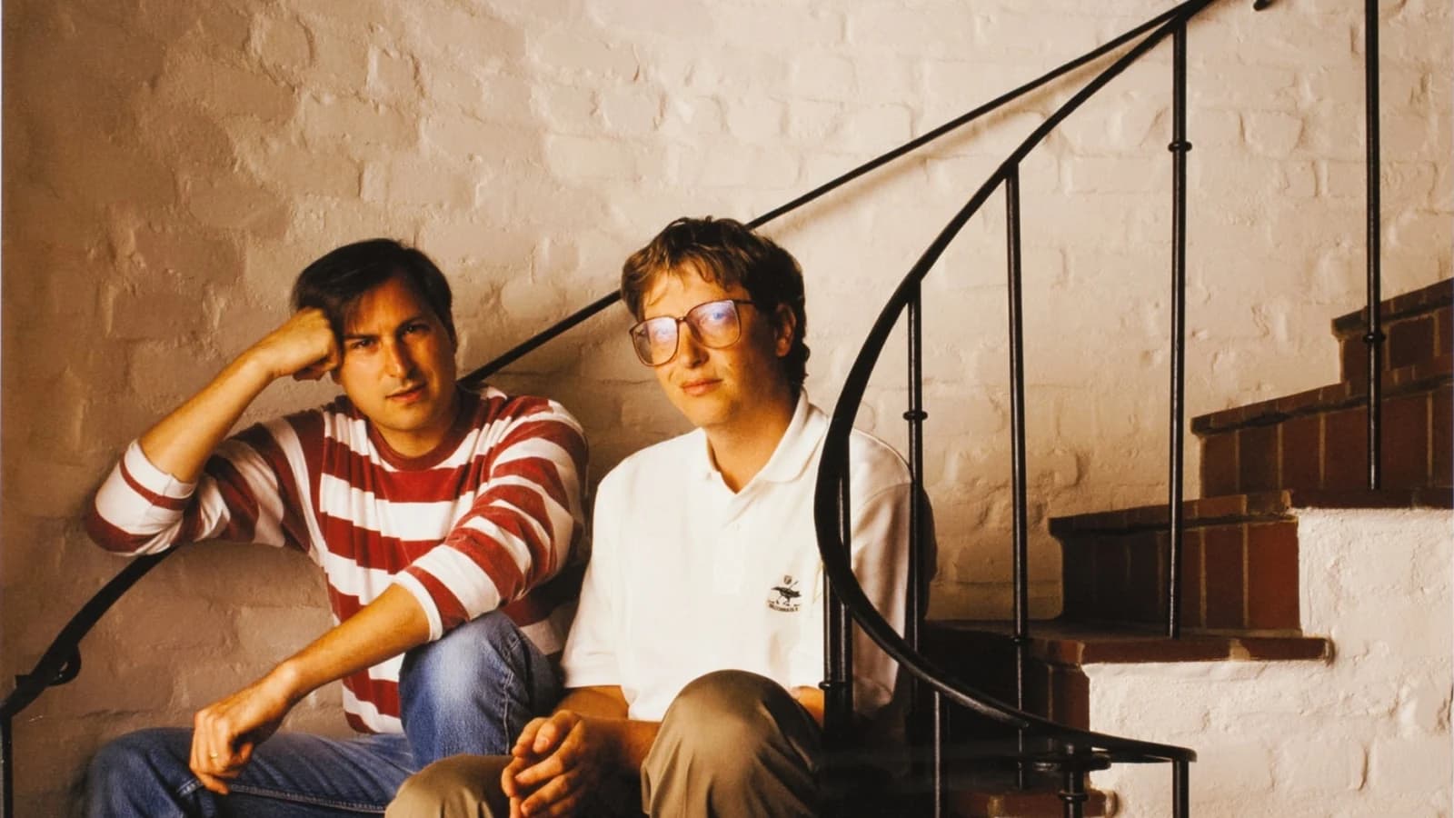 Steve Jobs and Bill Gates sitting together on a staircase