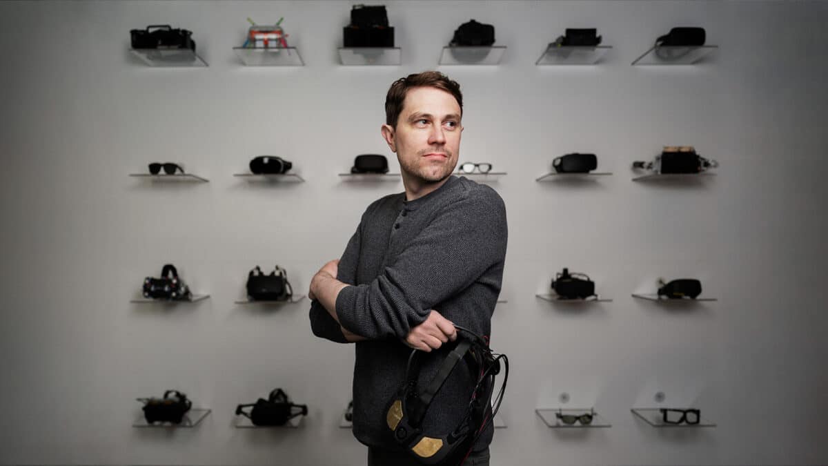 Reality Labs researcher Douglas Lanman standing in front of prototype headsets