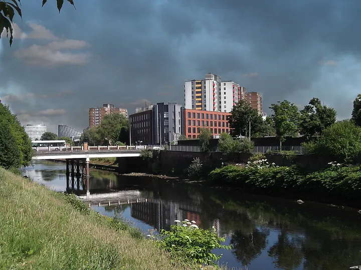 The River Irwell flowing through Salford beneath a cloudy sky