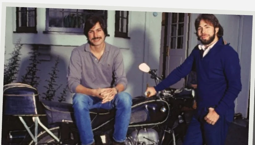 Steve Jobs and Steve Wozniak sitting beside a motorcycle