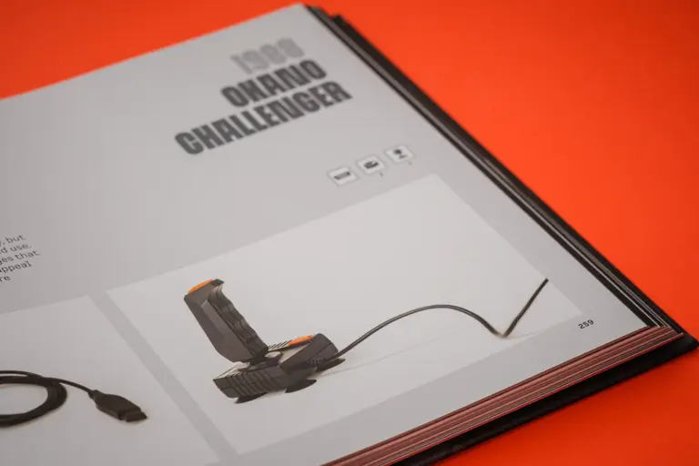 An open Trigger Happy book showing an Atari Onward Challenger controller
